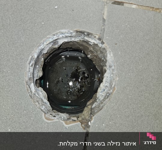 פתח ניקוז ברצפה עם סימני רטיבות